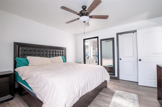 bedroom featuring a ceiling fan, wood finished floors, and ensuite bathroom