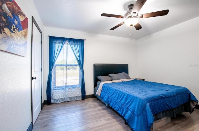 bedroom featuring a ceiling fan, wood finished floors, and baseboards