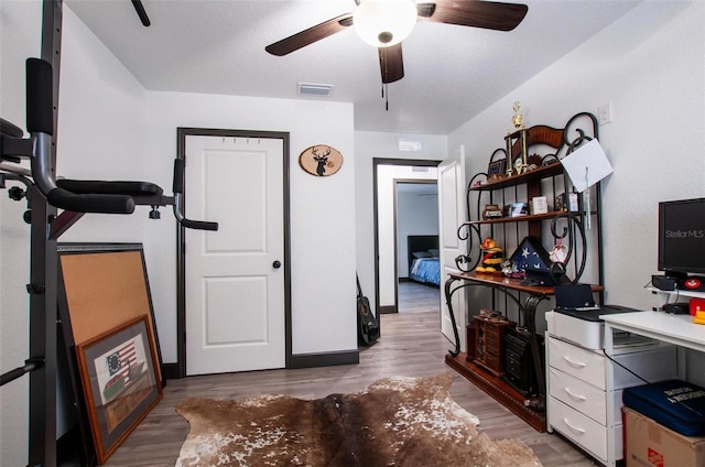 office space featuring visible vents, wood finished floors, and ceiling fan