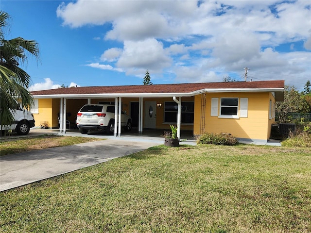 ranch-style home featuring central air condition unit, driveway, an attached carport, and a front yard