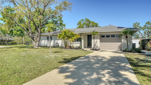 ranch-style home with concrete driveway, a garage, a front yard, and stucco siding