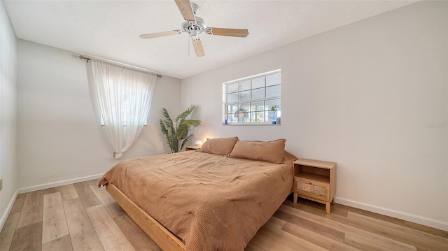 bedroom featuring baseboards, ceiling fan, and light wood finished floors