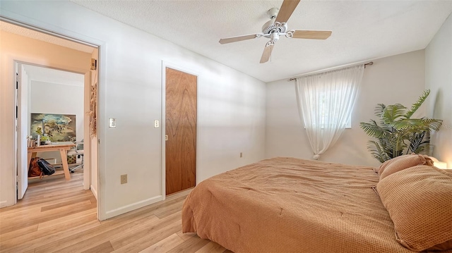 bedroom with light wood-style floors, a ceiling fan, and a textured ceiling