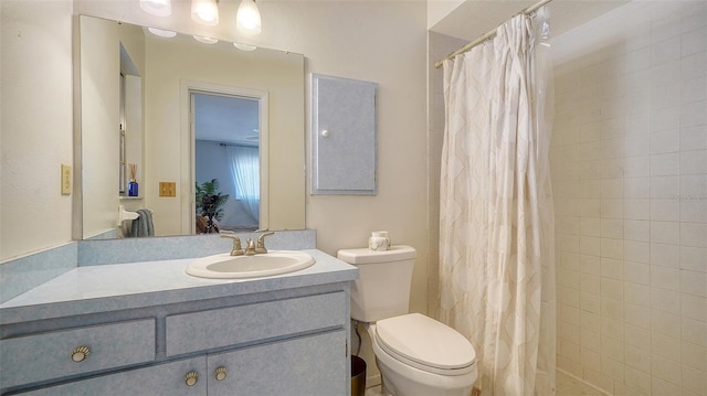 bathroom with tiled shower, toilet, and vanity