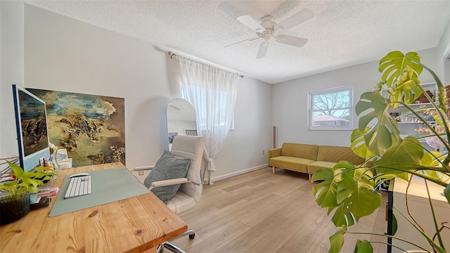 office area featuring ceiling fan, baseboards, a textured ceiling, and wood finished floors