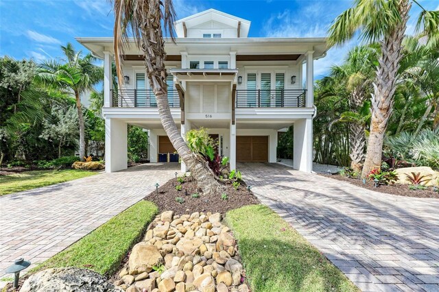 516 Kumquat Dr, Anna Maria, FL 34216 - coastal inspired home with a carport, a balcony, decorative driveway, and an attached garage