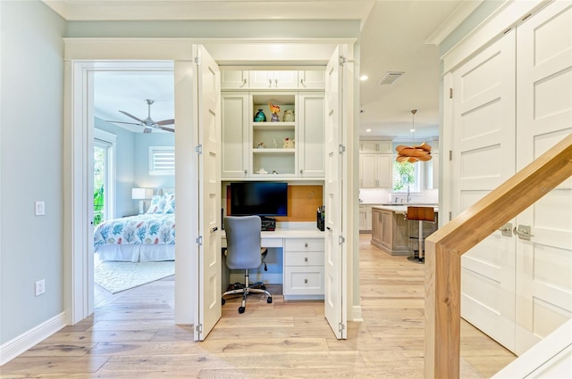 516 Kumquat Dr, Anna Maria, FL 34216 - office area featuring light wood-style floors, ceiling fan, ornamental molding, and built in desk