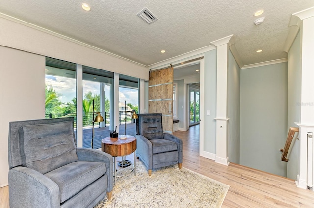 516 Kumquat Dr, Anna Maria, FL 34216 - sitting room with ornamental molding, wood finished floors, recessed lighting, a textured ceiling, and decorative columns