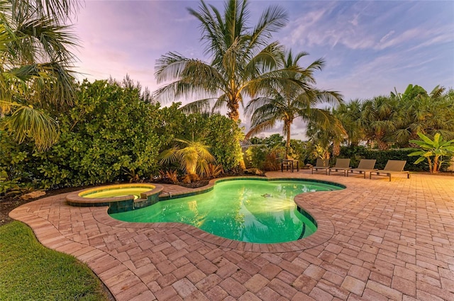 516 Kumquat Dr, Anna Maria, FL 34216 - pool at dusk featuring a patio area and a pool with connected hot tub