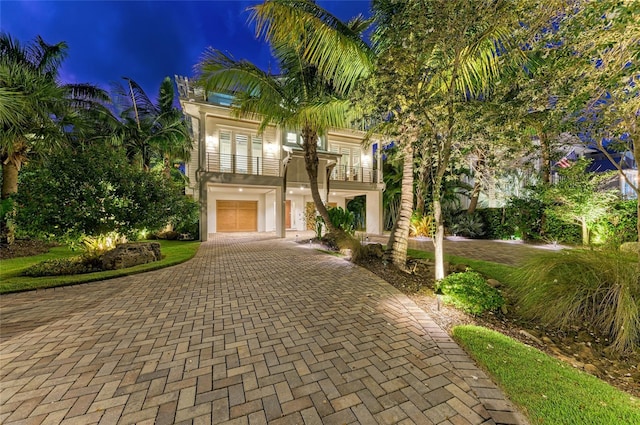 516 Kumquat Dr, Anna Maria, FL 34216 - view of front facade with a balcony, decorative driveway, a garage, and stucco siding