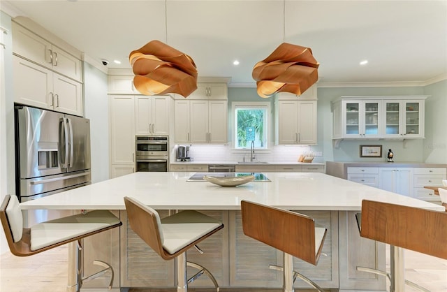 516 Kumquat Dr, Anna Maria, FL 34216 - kitchen featuring tasteful backsplash, stainless steel appliances, a center island, ornamental molding, and light countertops