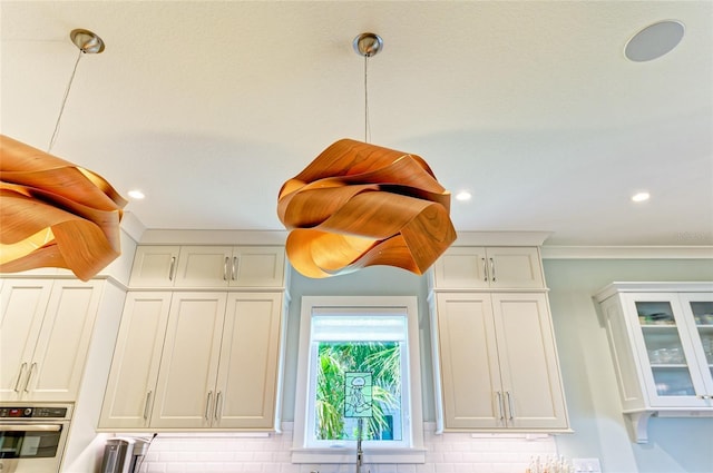 516 Kumquat Dr, Anna Maria, FL 34216 - kitchen view of backsplash, crown molding, white cabinets, oven, and recessed lighting
