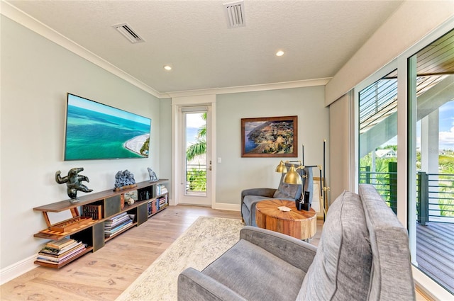 516 Kumquat Dr, Anna Maria, FL 34216 - living room with healthy amount of natural light, wood finished floors, ornamental molding, recessed lighting, and a textured ceiling