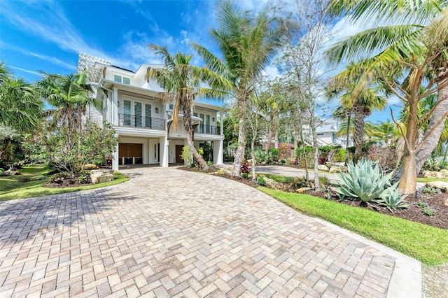516 Kumquat Dr, Anna Maria, FL 34216 - coastal inspired home with a balcony, decorative driveway, and an attached garage