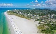 drone / aerial view with a water view and a view of the beach