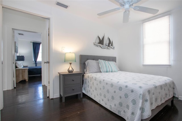 bedroom with visible vents, ceiling fan, dark wood-style floors, and baseboards