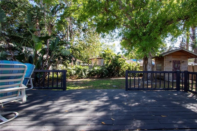 deck featuring fence, an outdoor structure, and a storage shed