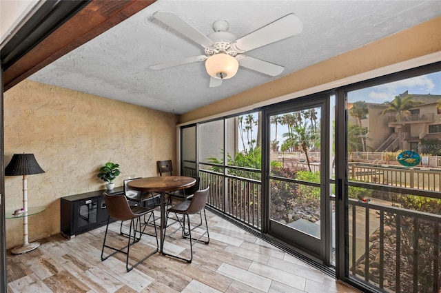 sunroom / solarium with a ceiling fan