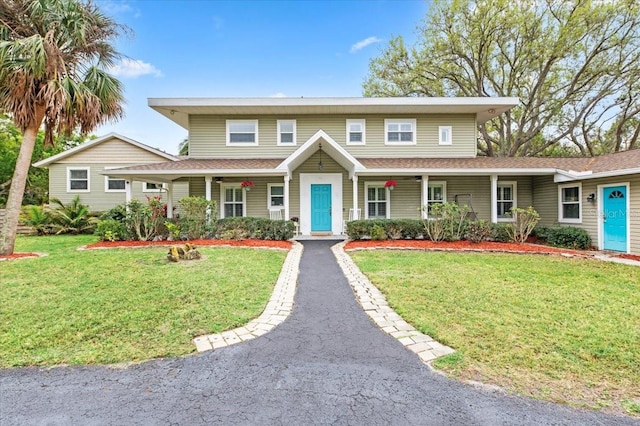 view of front of property with driveway, covered porch, and a front lawn