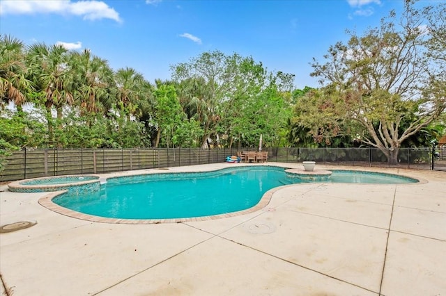 view of swimming pool with a patio, a pool with connected hot tub, and fence