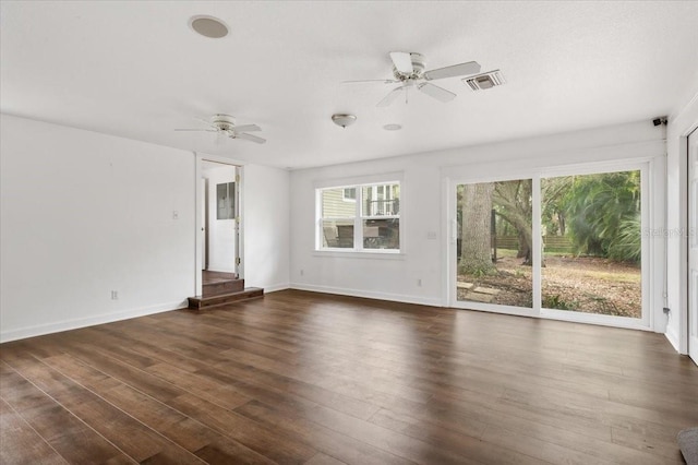 unfurnished living room with visible vents, baseboards, dark wood-type flooring, and ceiling fan