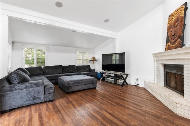 living area featuring a wealth of natural light, wood finished floors, a fireplace, and vaulted ceiling