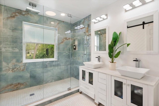 full bathroom featuring tile patterned flooring, a shower stall, double vanity, and a sink