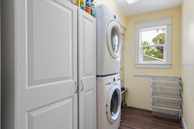 clothes washing area with cabinet space, stacked washer and dryer, and dark wood-style flooring