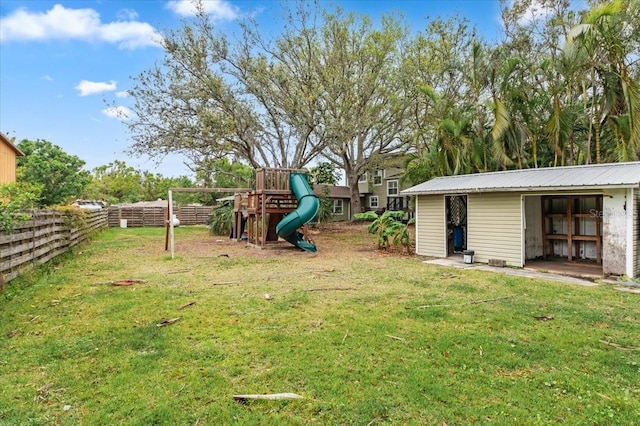 view of yard featuring an outbuilding, fence, and a playground