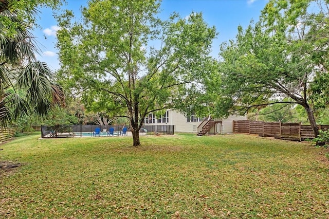 view of yard with a fenced in pool and fence