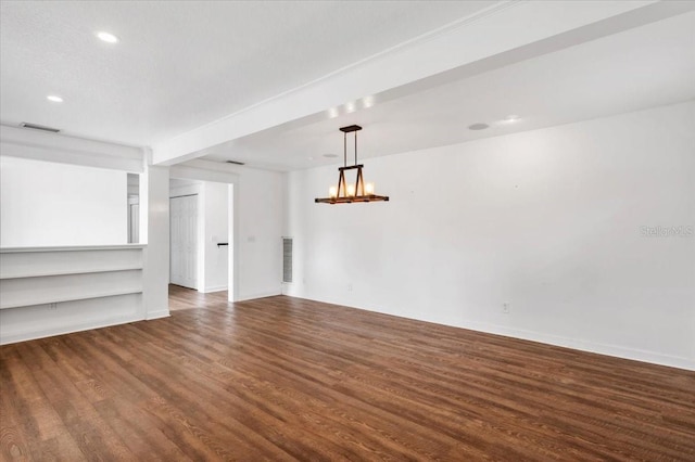 unfurnished room with baseboards, wood finished floors, visible vents, and a chandelier