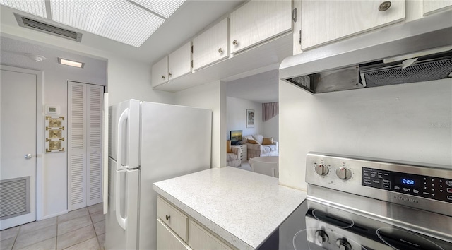 kitchen with freestanding refrigerator, visible vents, extractor fan, and electric range