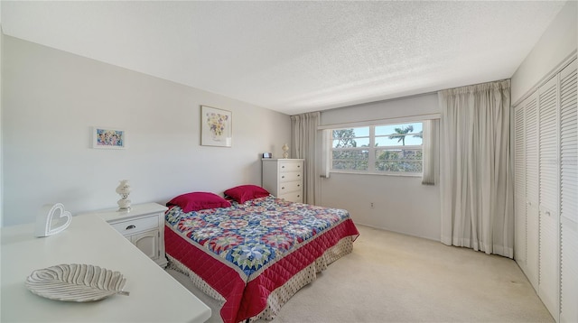 bedroom featuring a textured ceiling and light carpet