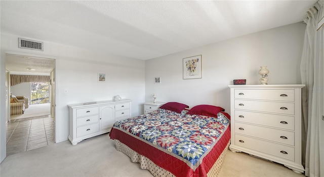 bedroom featuring visible vents and light colored carpet