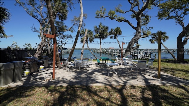 exterior space with fence, a dock, and a water view