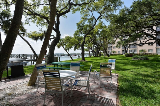 view of patio / terrace with grilling area and a water view