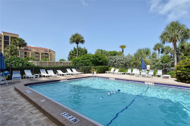 community pool featuring fence and a patio area