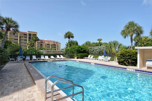 pool with a patio area and fence
