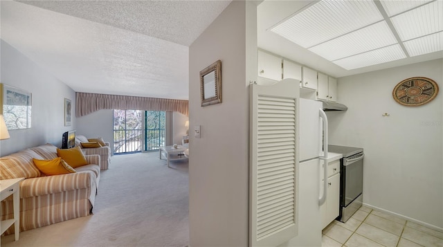 kitchen with under cabinet range hood, light countertops, stainless steel electric range oven, open floor plan, and white cabinetry