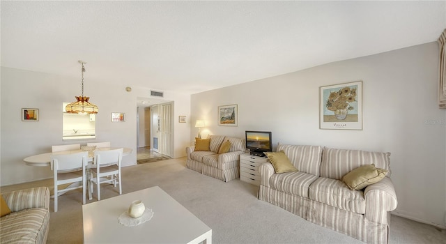 living area featuring visible vents and light colored carpet