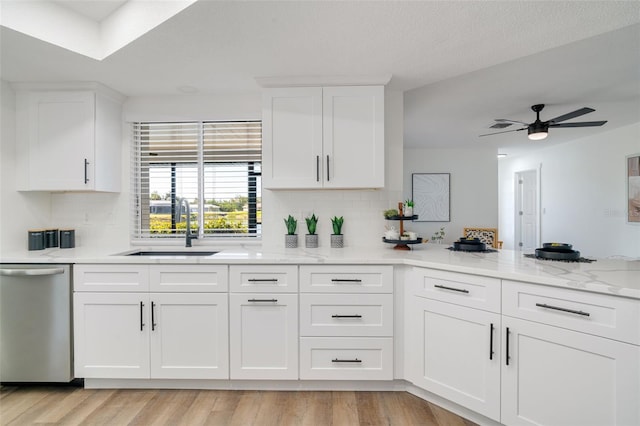 kitchen with light wood-style flooring, a sink, white cabinets, dishwasher, and ceiling fan