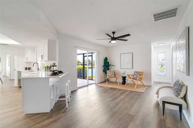 kitchen featuring visible vents, light wood-style flooring, a ceiling fan, white cabinets, and light countertops