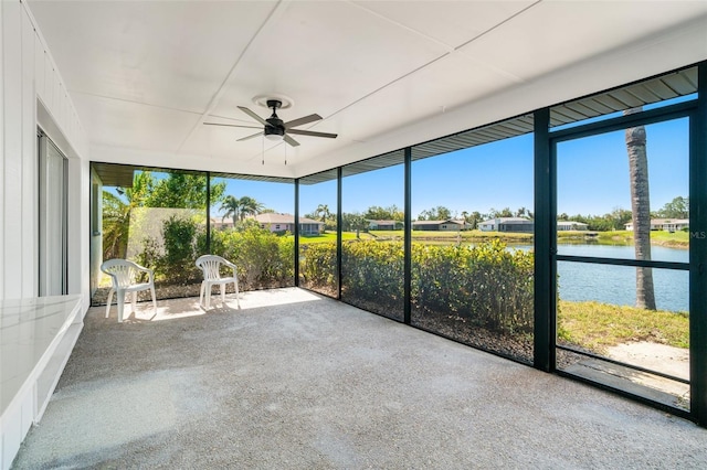 unfurnished sunroom featuring a water view and ceiling fan