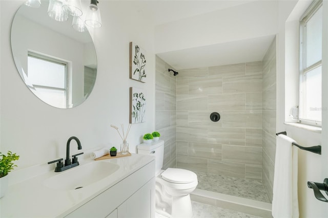 full bathroom with vanity, toilet, and a tile shower