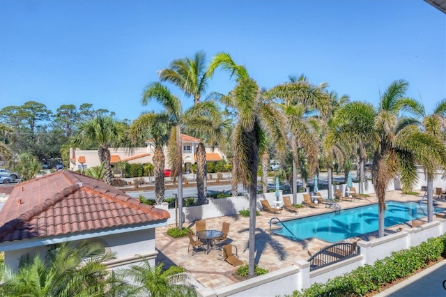 community pool with a patio and fence