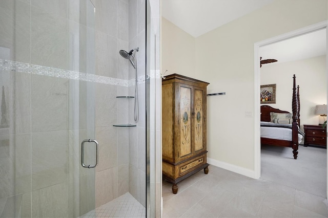 ensuite bathroom featuring tile patterned floors, connected bathroom, baseboards, and a stall shower