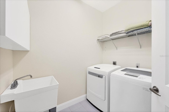 laundry room with a sink, baseboards, and washing machine and clothes dryer