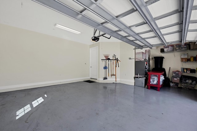 garage featuring heating unit, a garage door opener, and baseboards