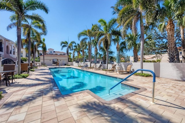 pool featuring fence and a patio area