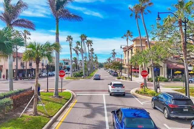 view of street featuring curbs, traffic signs, street lights, and sidewalks